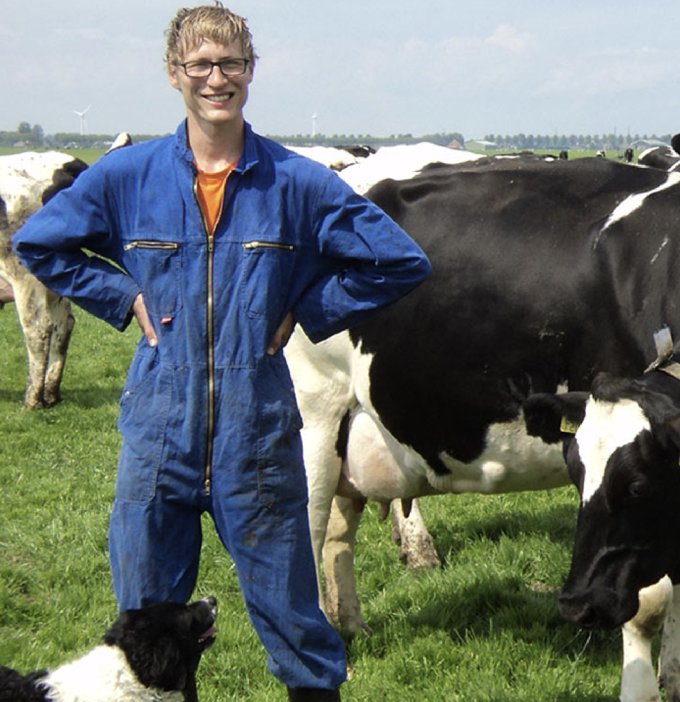 Melkveehouder op wei tussen koeien