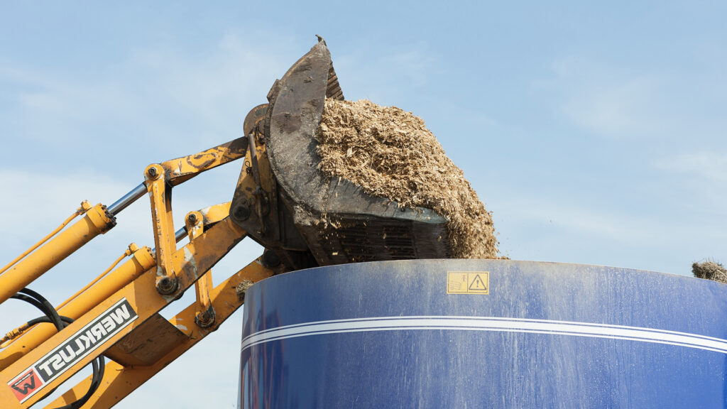 Loading Total Mixed Ration in mixer wagon using loader on dairy farm